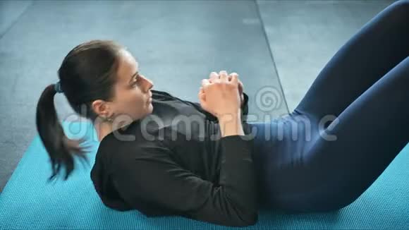 健身中心的年轻健康女性在垫子上做腹肌锻炼健康的生活方式和健身理念视频的预览图