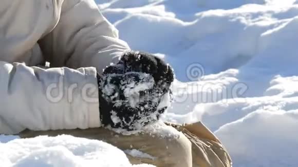 少年男孩玩雪做雪球冬天把雪扔在手里阳光明媚的冬日视频的预览图