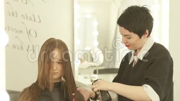 女理发师在美发沙龙理发时给头发喷洒水做女性发型师视频的预览图