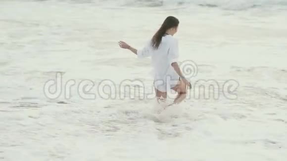 海浪冲刷着海边的女孩视频的预览图