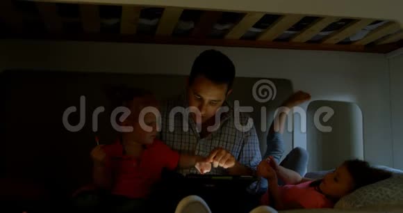 父亲和孩子在家里的卧室里使用数码平板电脑视频的预览图