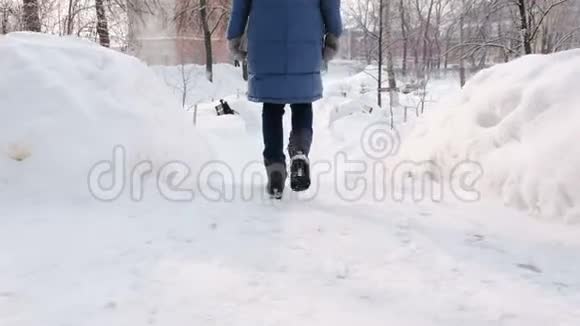 女人上了雪梯楼梯冬季公园白天在下雪的天气里下雪视频的预览图