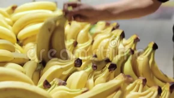女孩的手从商店的货架上拿香蕉健康的食物购物概念视频的预览图