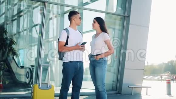 美丽的一对相爱的夫妇站在机场航站楼附近互相交谈商业合同交易视频的预览图