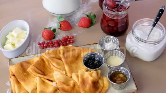俄罗斯传统煎饼布里尼提供果酱酸奶油和草莓盘特写侧视视频的预览图