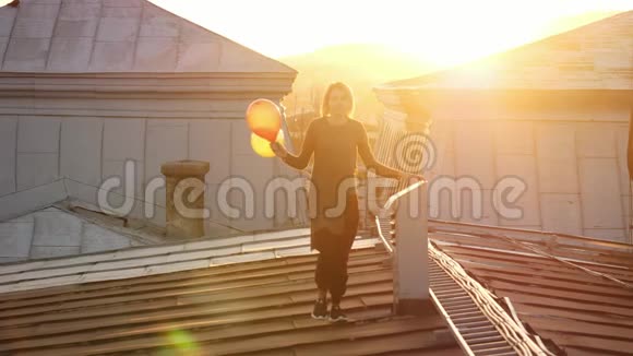 女人在屋顶上用气球奔跑感到快乐视频的预览图