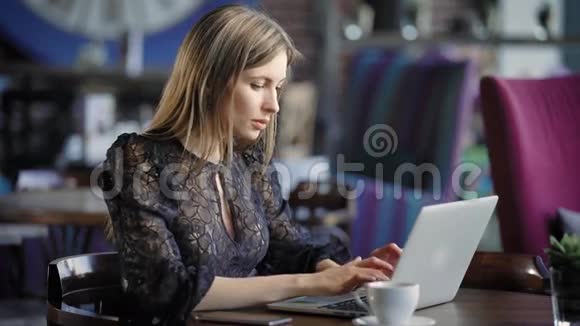 一个漂亮的女人在咖啡馆里用笔记本电脑工作严肃的商务小姐午餐休息时在线点餐视频的预览图