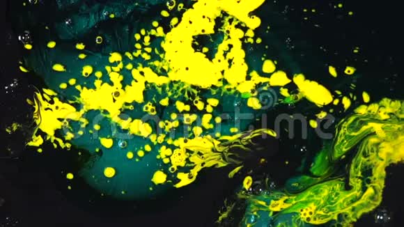 特写黄色和蓝色油漆污渍与深色表面混合色彩创作与艺术理念视频的预览图