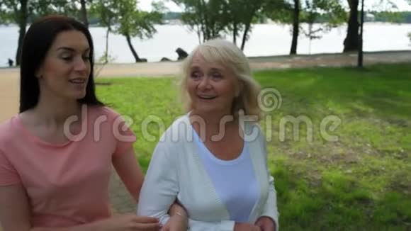 积极的沃姆和她退休的母亲在公园散步视频的预览图