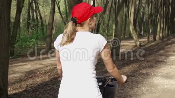 动作缓慢女人骑自行车女青少年骑自行车在阳光公园积极运动概念视频的预览图