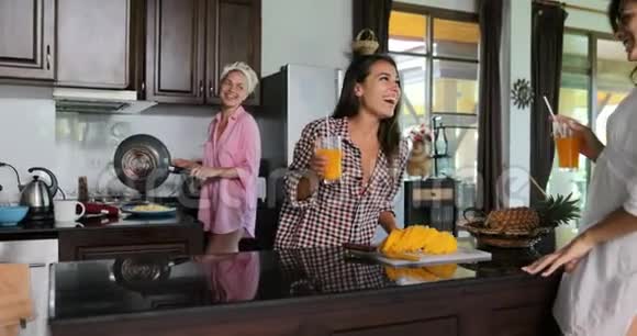 女孩团体谈话饮酒果汁大笑烹饪早餐早间厨房工作室现代室内视频的预览图