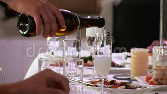 服务员把香槟酒白起泡酒倒入玻璃杯中泡沫上升一家餐馆视频的预览图