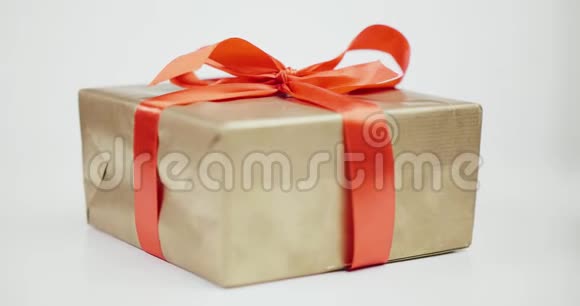 棕色礼品盒系着红色丝带蝴蝶结白色背景隔离视频的预览图