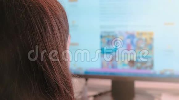 在电脑上工作无法辨认的年轻女性在屏幕上浏览网页并在网上购物视频的预览图