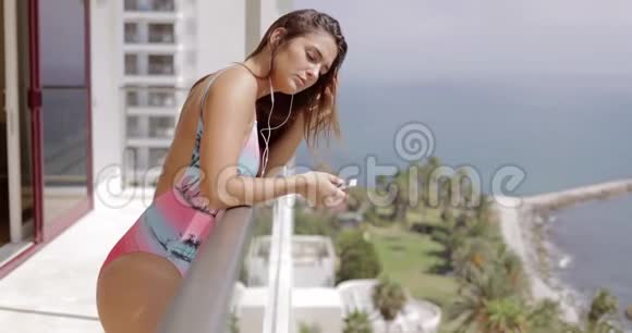 酒店阳台上有小玩意的年轻女孩视频的预览图