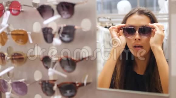 年轻的混合种族少女尝试太阳镜和在购物中心闲逛有趣的时尚看4K慢动作视频的预览图