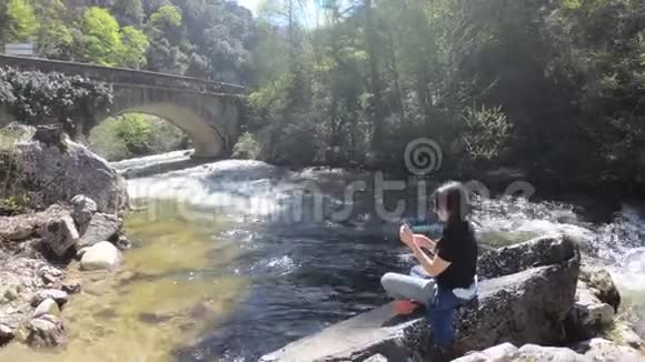 一位年轻女子独自在河边用手机拍照法国视频的预览图