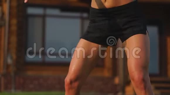 美丽的黑发女人在一个大豪宅的背景下从事健身房和表演蹲在露天锻炼视频的预览图