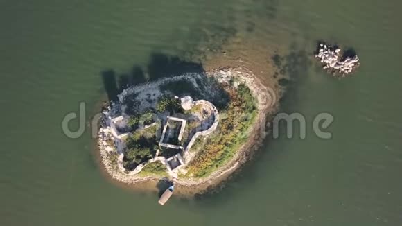 有废墟的小岛的俯视图库存在被大海包围的小片土地上旧房子的废墟被遗忘的地方视频的预览图