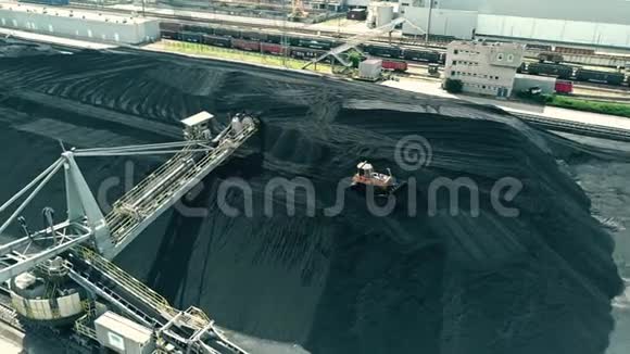电厂煤堆顶部移动推土机的鸟瞰图视频的预览图