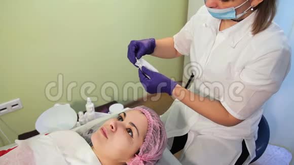 美容师拿出一个一次性敷药器来进行中间治疗面部年轻化程序的准备视频的预览图