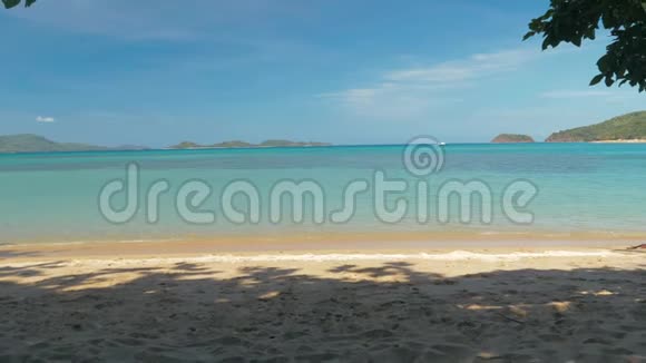 一个绳子秋千的特写挂在棕榈树上在一个美丽的海滩上白色的沙子和绿松石的水在秋千上摇晃视频的预览图