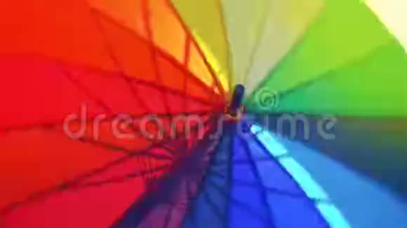 一把张开的彩虹色的大伞一把五颜六色的伞在开阔的视野中旋转视频的预览图