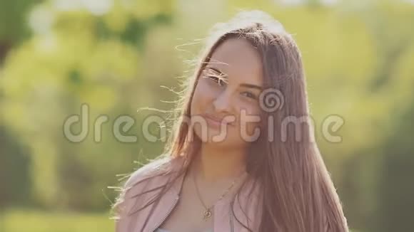 年轻漂亮的女孩在镜头前摆姿势手一摸到长发夏天自然视频的预览图