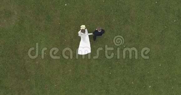 科普特对婚礼的看法新郎和新娘在森林环绕的大公园里散步视频的预览图
