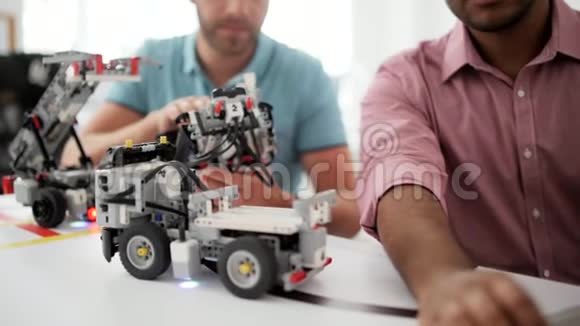 两个年轻的专业人士在制造机器人和看手提电脑视频的预览图