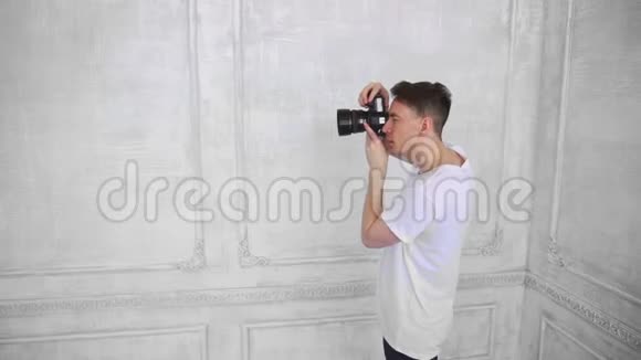 摄影师在白色室内工作室为一个漂亮的女孩拍照视频的预览图