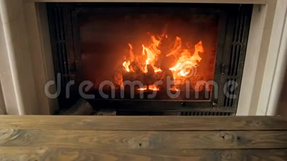 客厅带木桌子的壁炉中缓慢燃烧的火焰画面视频的预览图