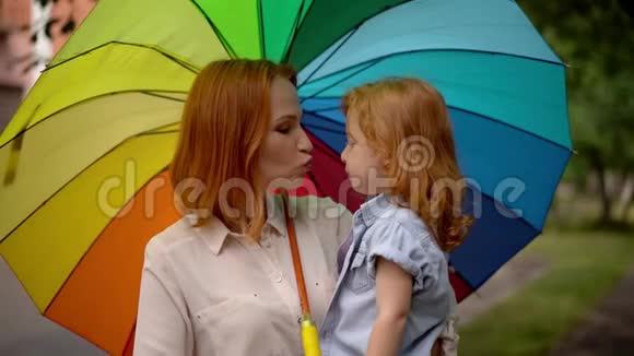 妈妈和女孩在大自然的彩伞下视频的预览图