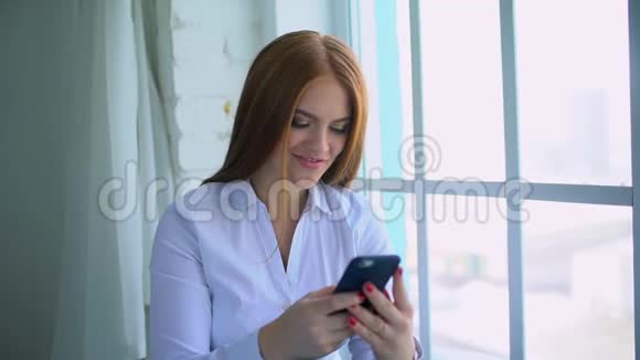 年轻女孩使用便携式小工具浏览社交网络20s机型通过触摸屏手握在线交流视频的预览图