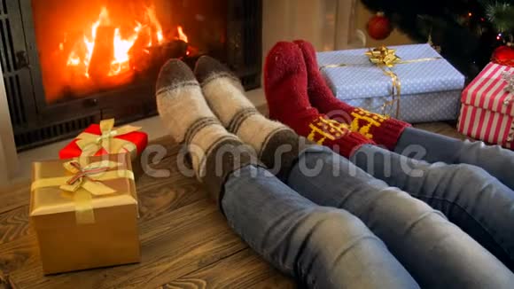 在圣诞节的夜晚家人穿着羊毛袜在壁炉旁放松视频的预览图