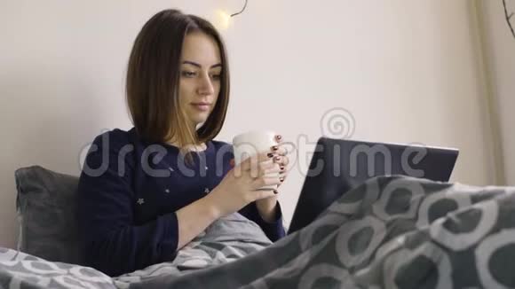 躺在床上用笔记本电脑喝咖啡的美女视频的预览图