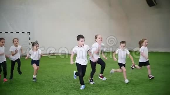 孩子们在室内足球场踢足球跑步视频的预览图