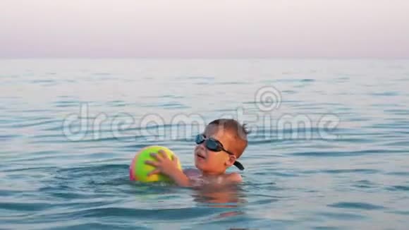 快乐的孩子用球在海里洗澡视频的预览图