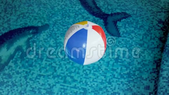 4k条纹彩色沙滩球在游泳池漂浮视频视频的预览图