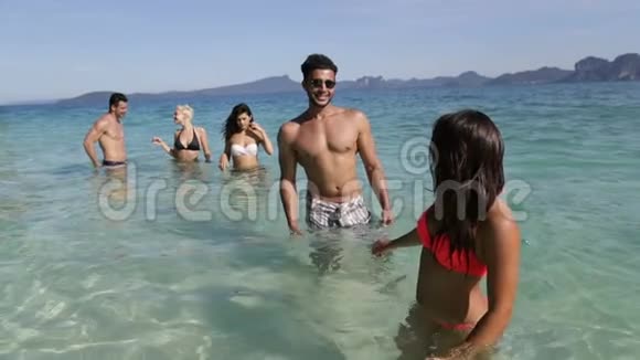 快乐微笑的女人牵着男人的手牵着他从海边的人们海上度假的旅游团视频的预览图