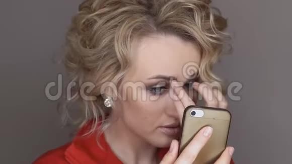 一个穿红色衣服的女孩自己在手机上拍照视频的预览图