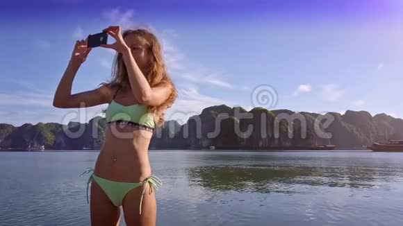 小苗条女孩站在船上的照片湾和岛屿视频的预览图