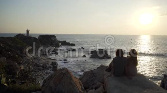 年轻夫妇坐在悬崖上视频的预览图