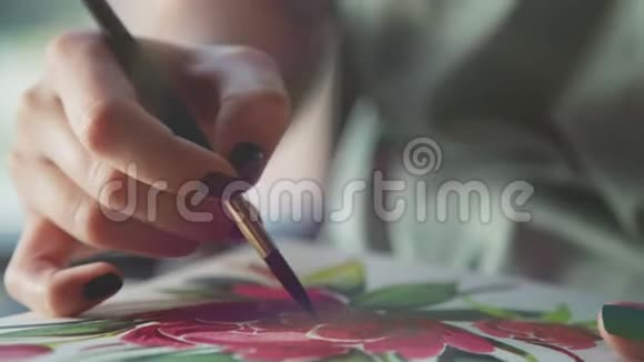 女人手里拿着画笔用猩红的颜料在相册里画画视频的预览图