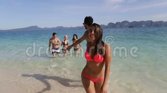快乐微笑的女人牵着男人的手牵着他从海边的人们海上度假的旅游团视频的预览图