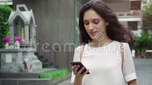 女孩走在城市街道上喝着咖啡以超慢的速度前进视频的预览图