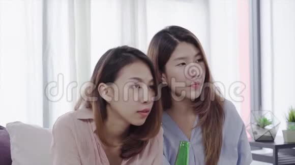 一群亚洲女性狂热球迷在电视上观看足球比赛在沙发上庆祝进球尖叫兴奋视频的预览图