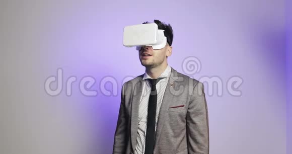 穿西装的人使用虚拟现实的眼镜或护目镜并在自己周围旋转视频的预览图