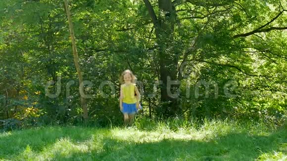 活跃的小女孩正在公园里跑步在绿草上玩户外活动视频的预览图
