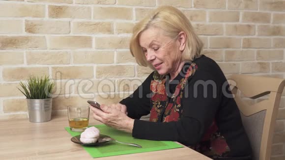 快乐的老年妇女使用智能手机视频的预览图